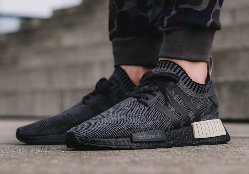 The adidas NMD R1 Primeknit “Pitch Black” Adds Tan Heel Bumpers