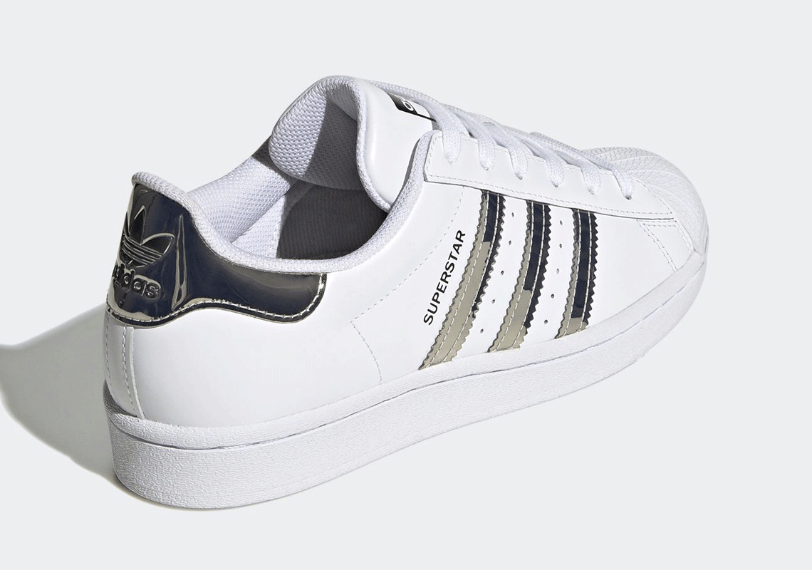 black adidas with silver stripes